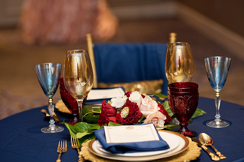 Red and navy wedding reception plate setting.